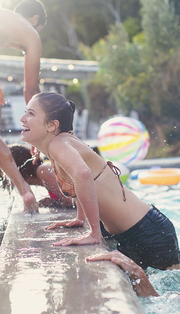 Friends swimming in pool at pool party