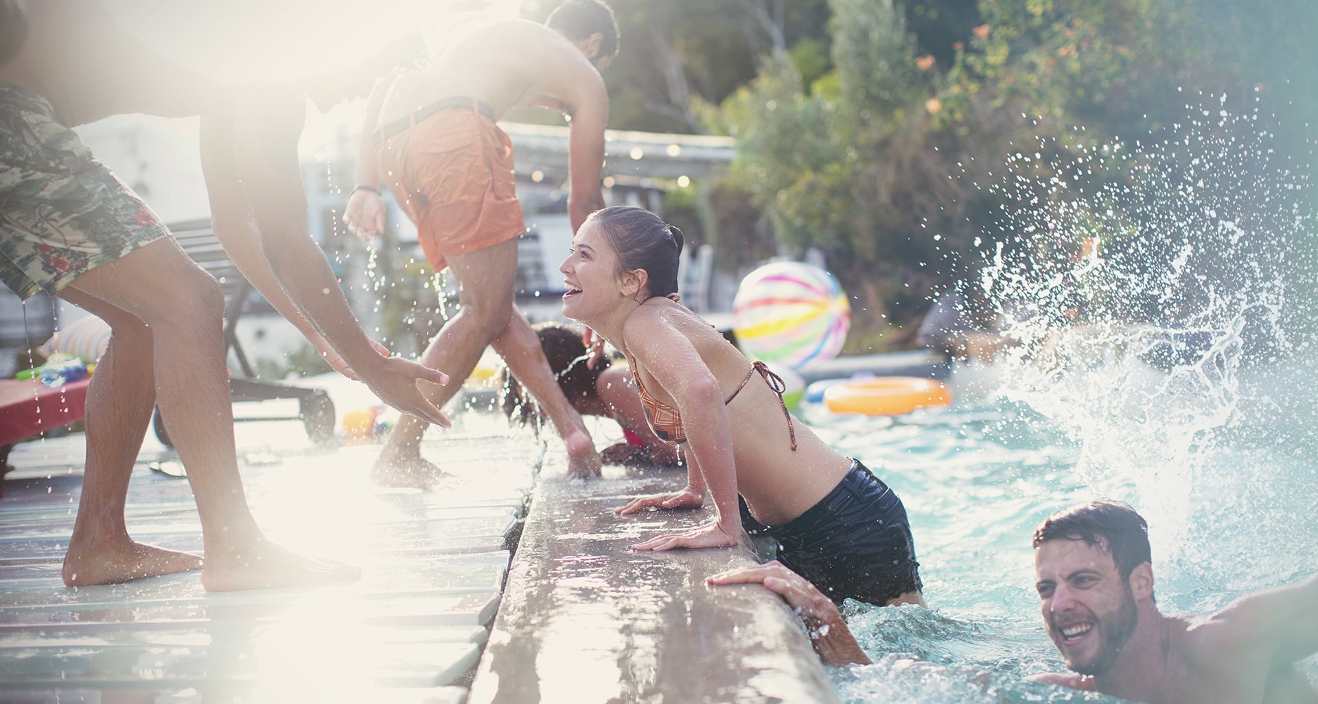 Friends swimming in pool at pool party